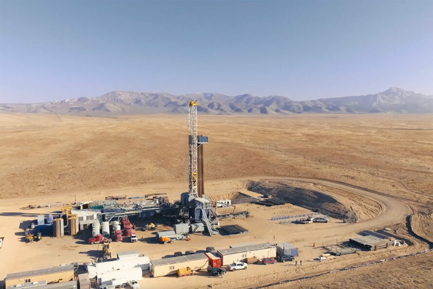 A geothermal plant in front of mountains.